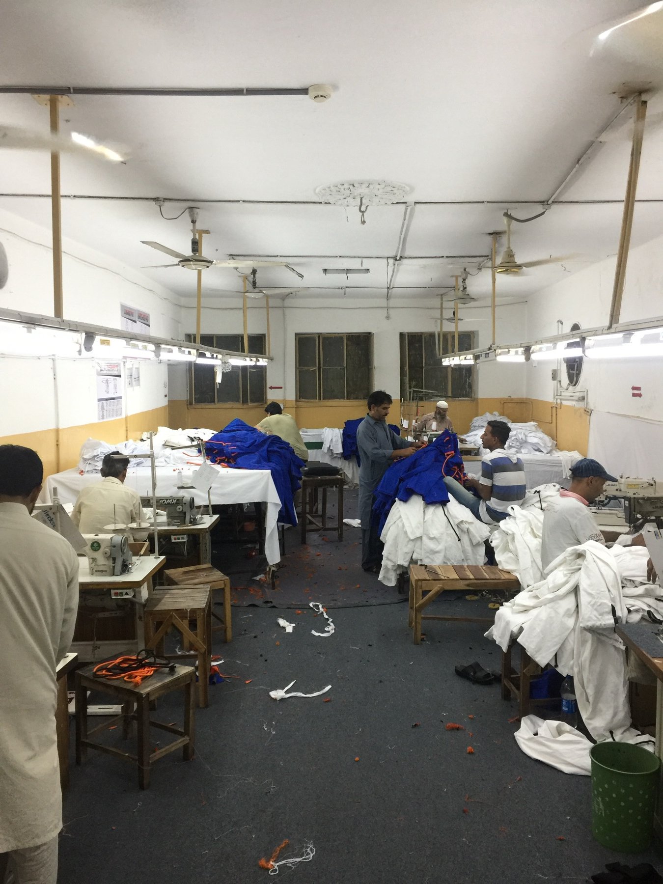 Workers stitching Brazilian jiu-jitsu gis on the Special Sporting factory floor in Sialkot